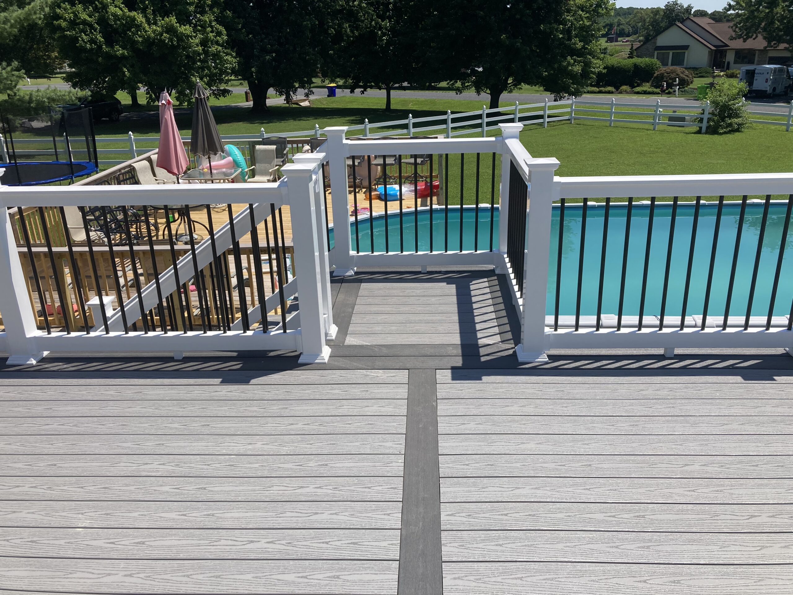 The large deck installation opens to steps down to a pool area.