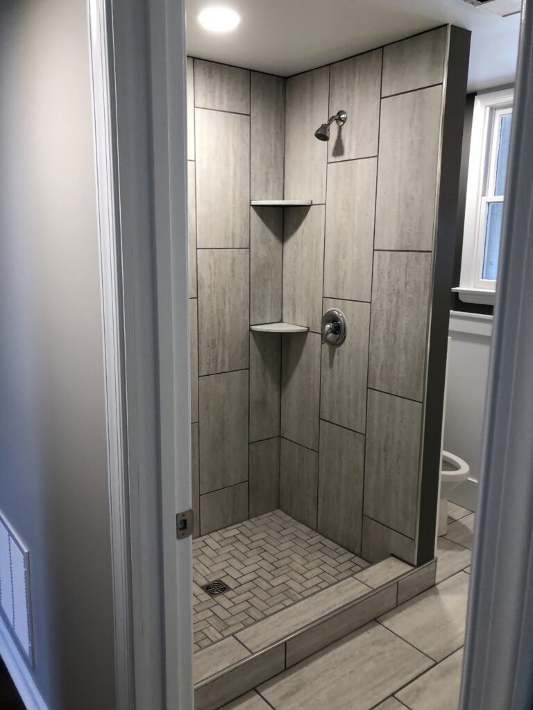 A second stone tiled shower stall with an industrial aesthetic