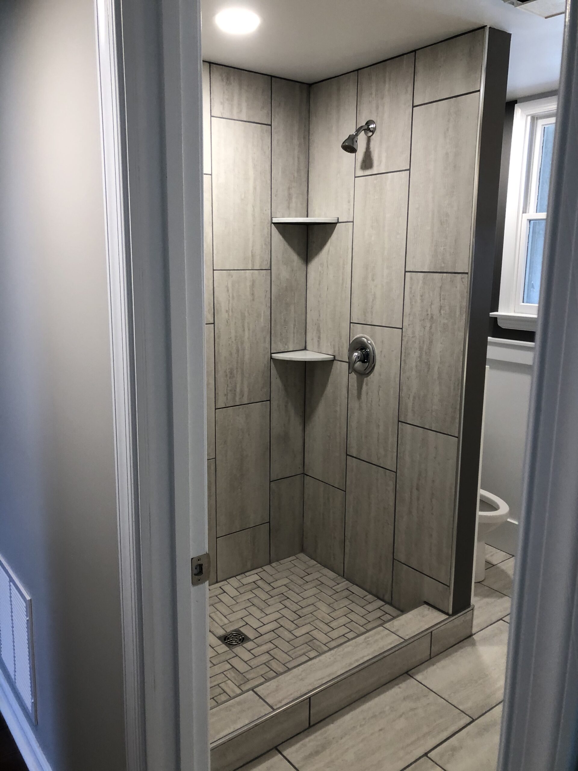 A second stone tiled shower stall with an industrial aesthetic