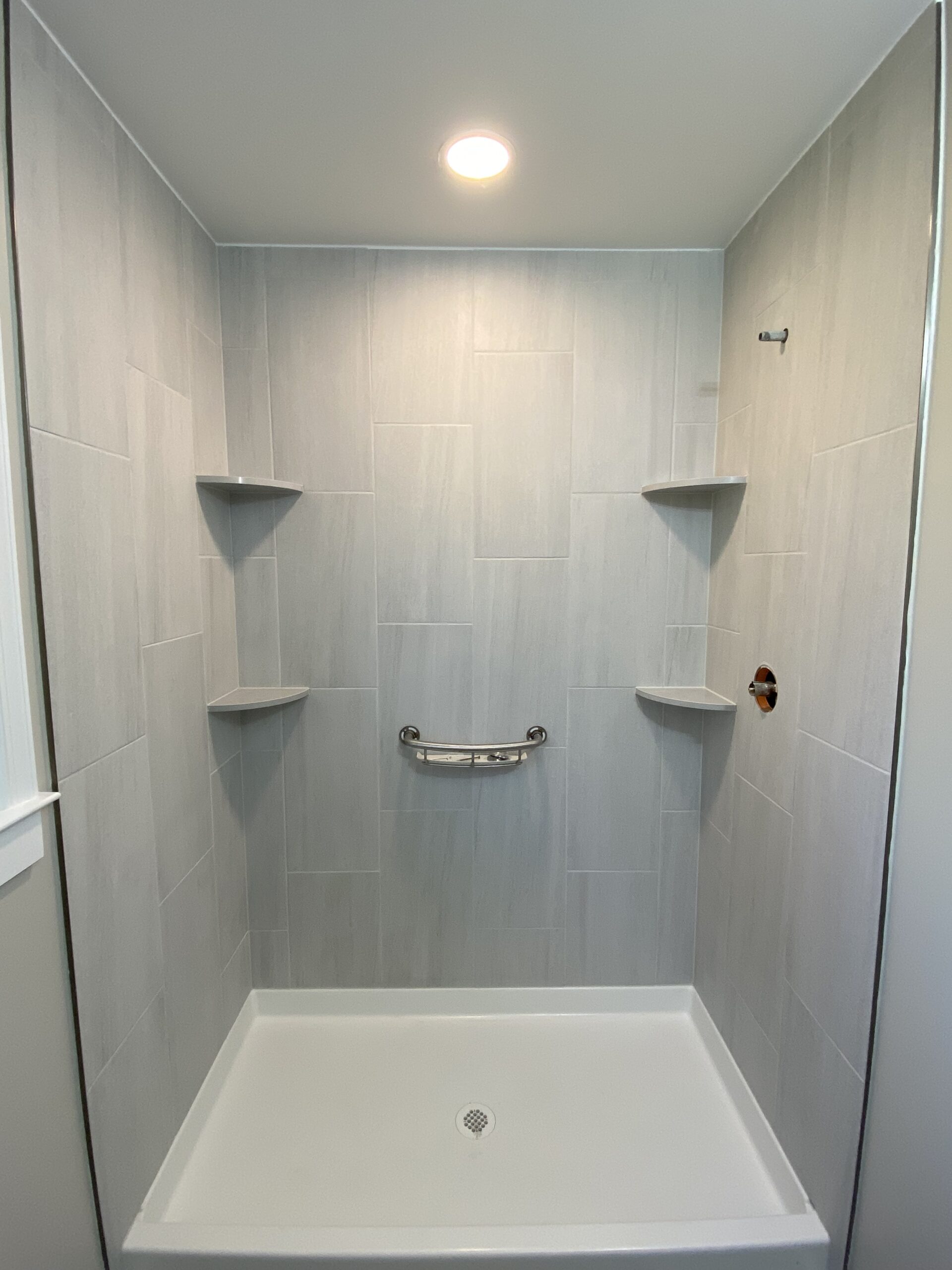 The shower stall interior with modern fixtures and clean lighting.