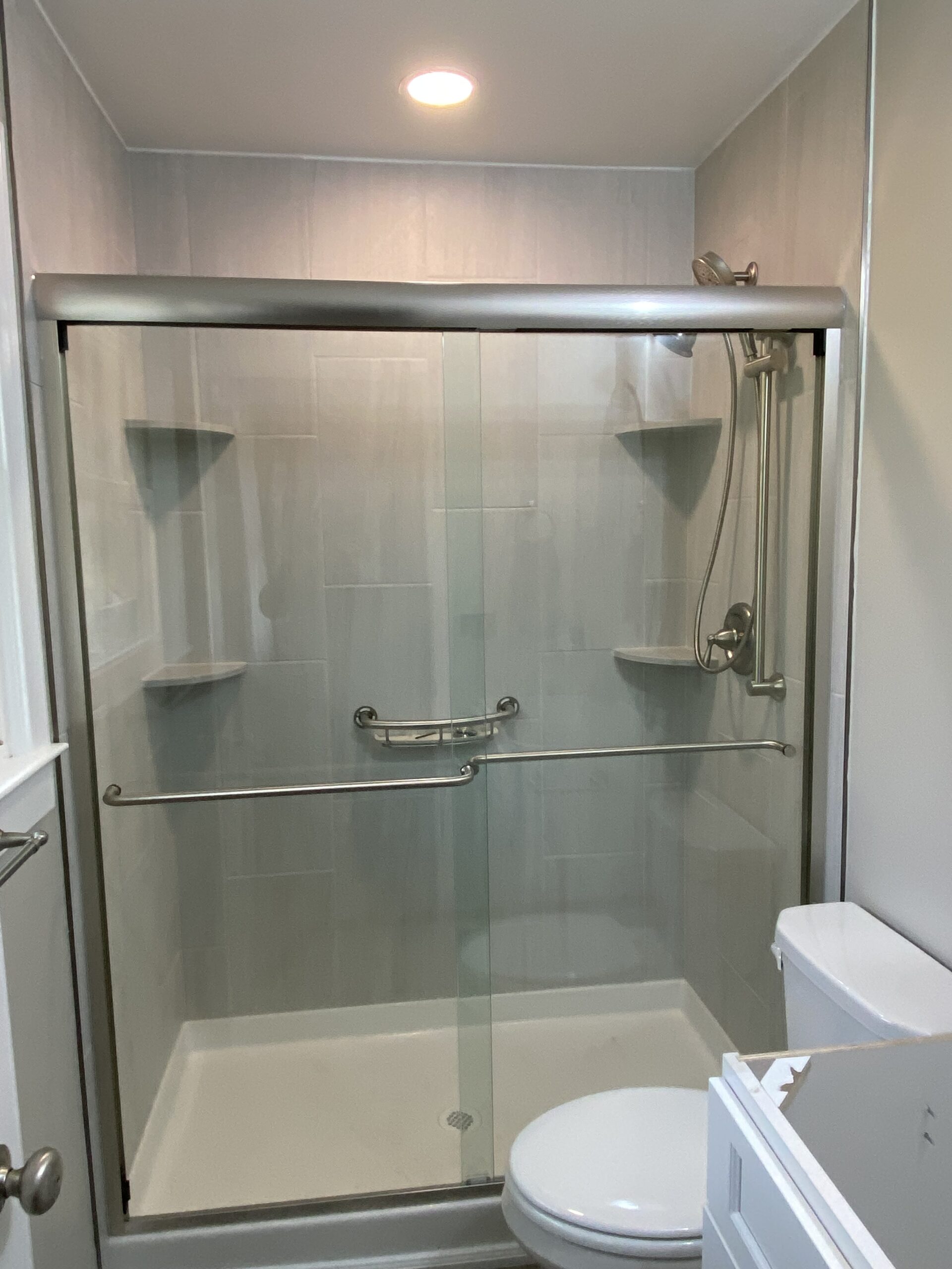 Another view of the remodeled shower stall, with closed glass doors.