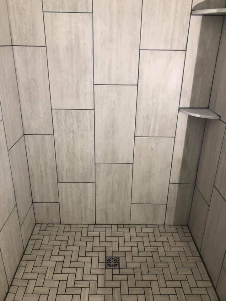 Closeup on the excellent tilework in the shower stall, contrasting large tiles on the well with small ones on the floor.